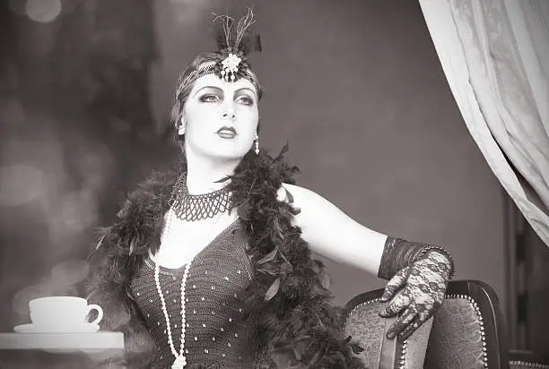 Black and White Portrait of The Beautiful Retro woman Drinking Tea in the Cafe in Black Lace and Accessories  in Style 1920s - 1930s 