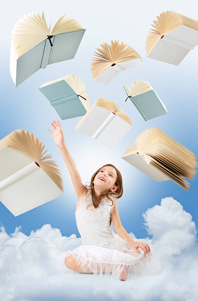 istock Flying books over little girl looking up 472182303