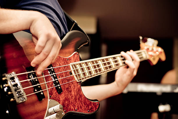 músico tocando una guitarra - bass guitar fotografías e imágenes de stock