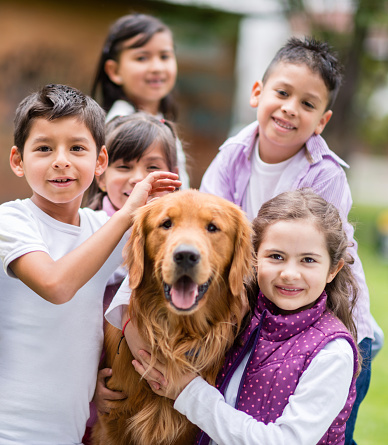 Happy group of kids with a dog at the park