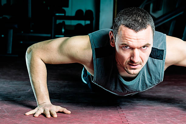 istock Handsome Muscular Men performing push ups in gym 472184341