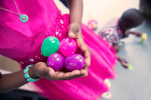 This is a close up, color photograph of a black girl holding easter eggs.