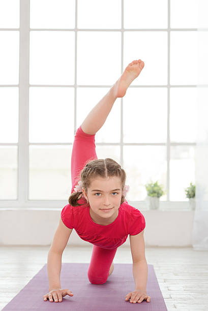 istock Little girl doing yoga exercise 472185856