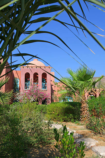 Summer holiday joy Taba, Egypt - September 20, 2010: Quiet corner of hotel resort in green tropical garden against beautiful hotel building, sunny summer morning, Taba Heights, Sinai, Egypt taba stock pictures, royalty-free photos & images