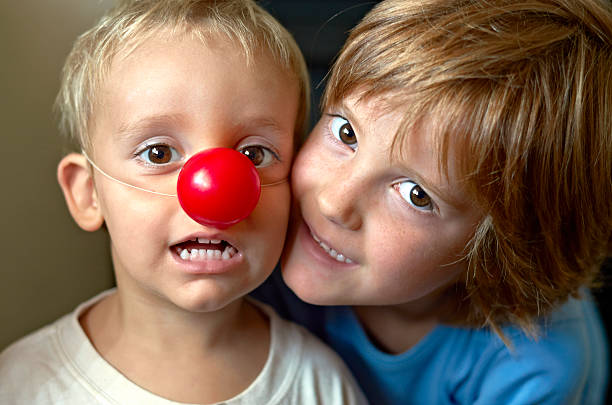 istock Happy children. Playing with clown's nose 472188162