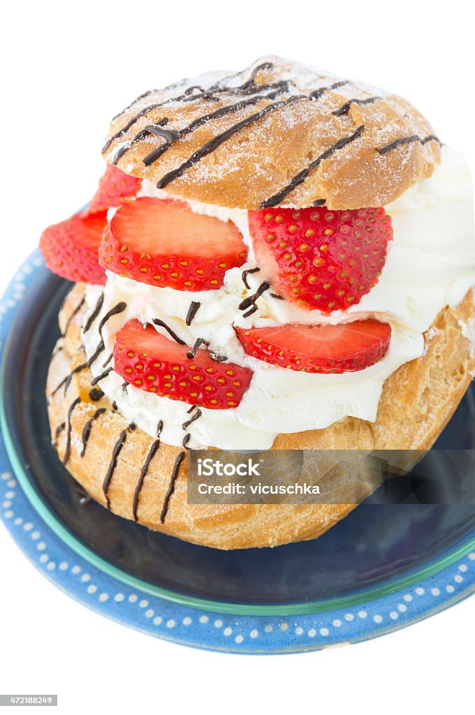 German Cream Puffs with strawberries in blue bowl, isolated Baked Pastry Item Stock Photo