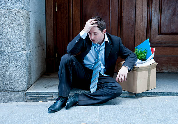 istock frustrated business man on street fired carrying cardboard box 472188441
