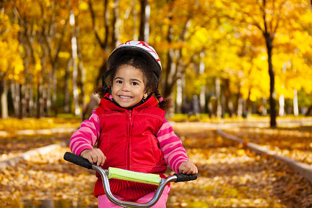 istock Smiling little girl on a bicycle 472188565