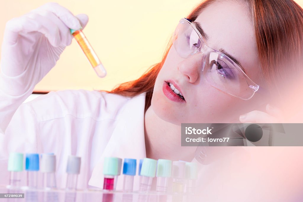 Scientist working in laboratory Scientist reviewed a sample of blood and calling the doctor. Adult Stock Photo