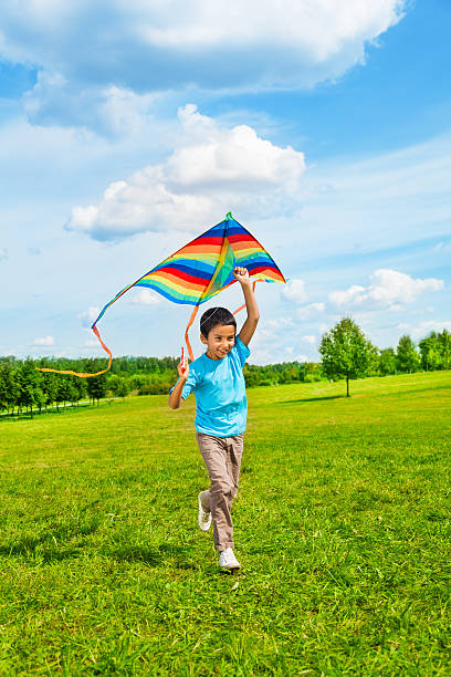 istock 6 years old boy running with kite 472189661