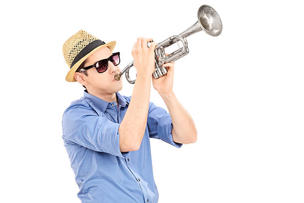 istock Young male musician blowing into a trumpet 472189875