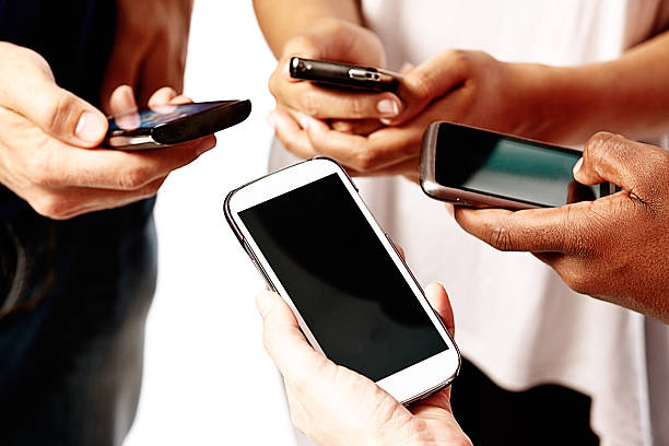 istock Four individual hands busy on mobile phones 472190999