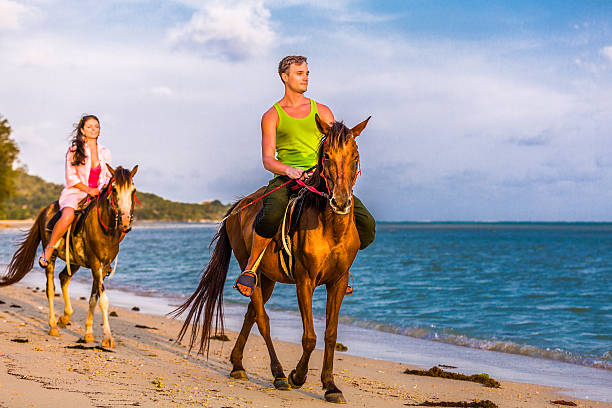 istock Couple riding horses at sunset 472191267