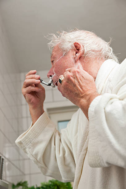 istock Senior man shaving his beard in bathroom. 472193035