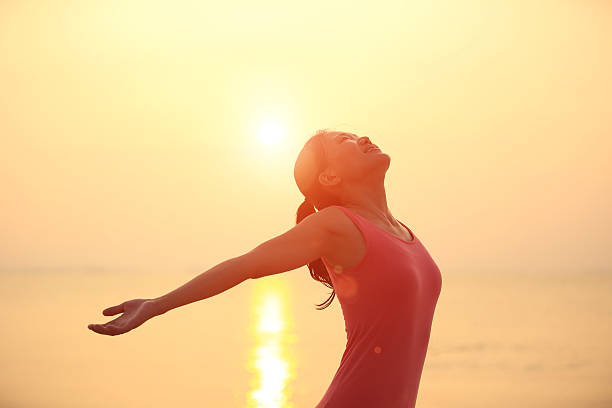 istock cheering woman open arms  at sunrise beach 472193665