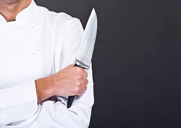 Closeup photo of a chef's knife being held up stock photo