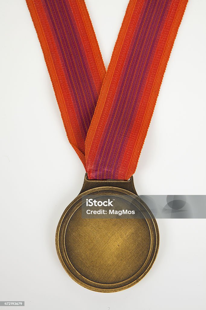 Gold Medal isolated on white background A gold medal hanging from multicolored ribbon. Clipping path included. Achievement Stock Photo