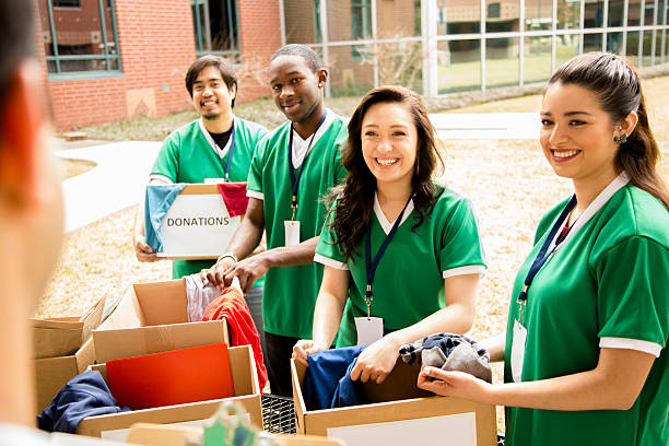 i volontari: studenti universitari raccogliere abbigliamento donazioni alla comunità. - relief foto e immagini stock