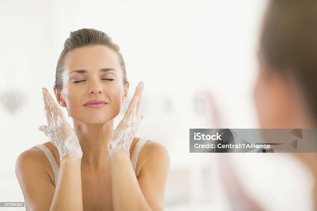 young woman washing face in bathroom Young woman washing face in bathroom Adult Stock Photo
