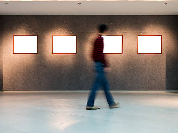 istock Blurred out guy walking past paintings in an art gallery 472195703