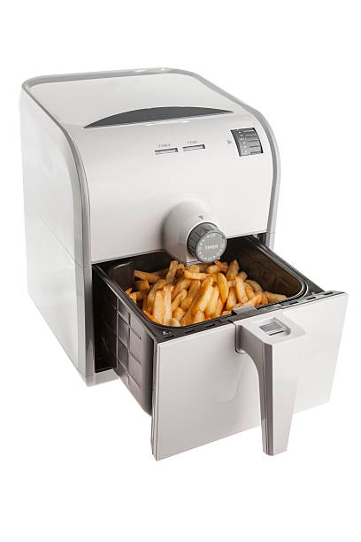 Isolate Electric fryer with full basket of french fries Electric fryer with basket full of french fries deep fryer stock pictures, royalty-free photos & images