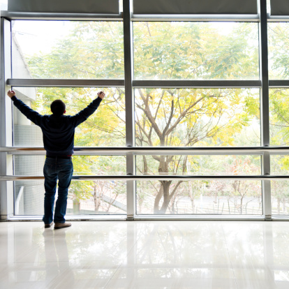 Man with arms raised in a modern business building.
