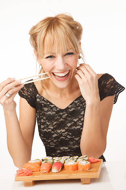 istock Cheerful young woman with sushi 472196852