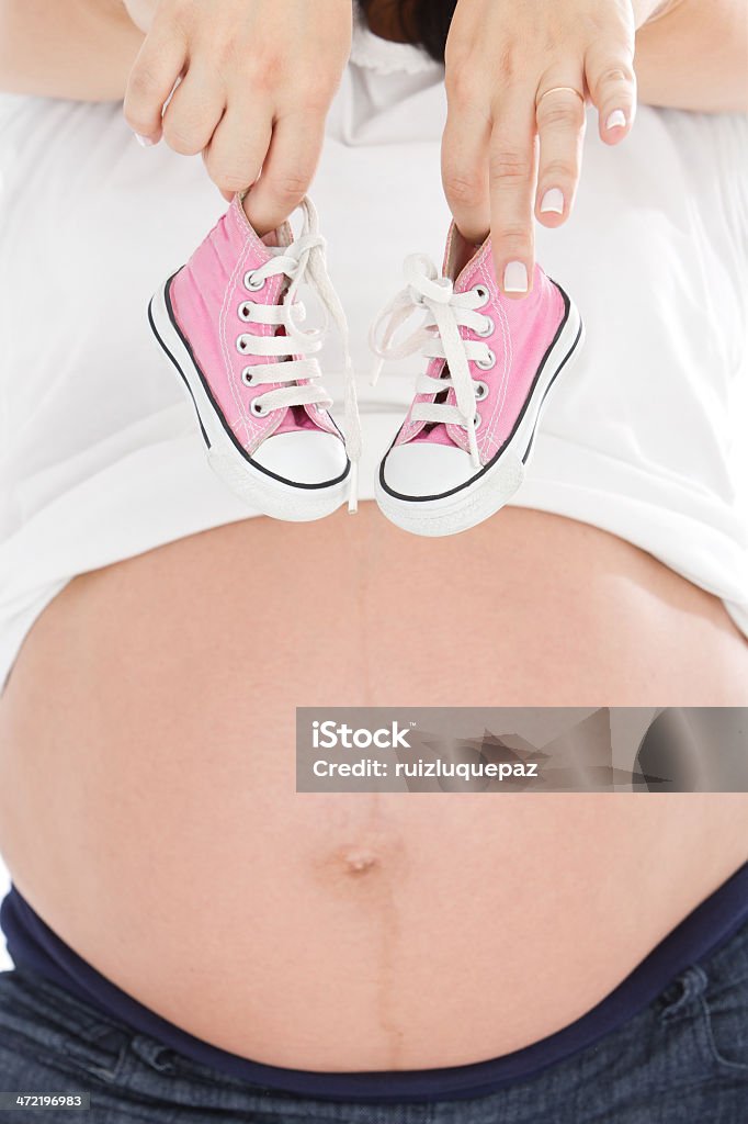 Bella incinta, pancia con Rosa pantofole - Foto stock royalty-free di Incinta