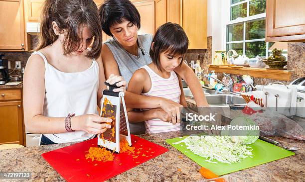 Family Mother With Two Daughters Cutting Vegetables For Salad Stock Photo - Download Image Now