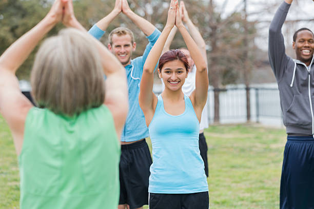 istock Active young people stretching in fitness class with senior instructor 472197497