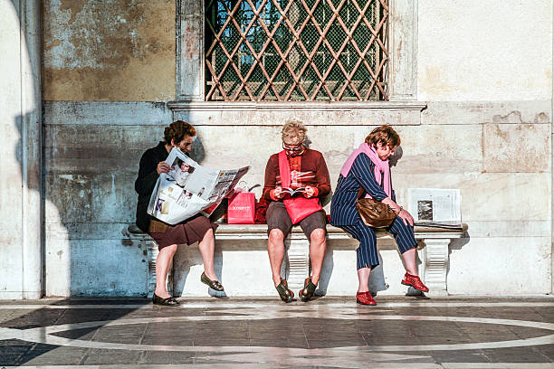 Three men sitting on a bench of the public park of Planty krakowskie in Krakow Poland during summer day