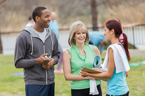 istock Instructor answering questions about outdoor exercise yoga class 472197999