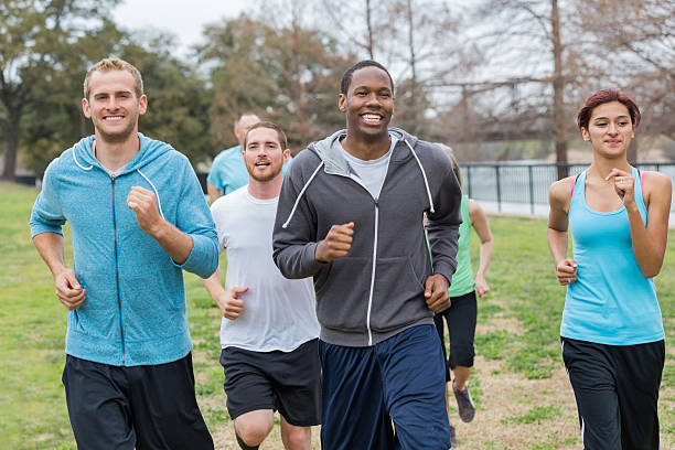 istock Group of athletic people running together at park 472198287