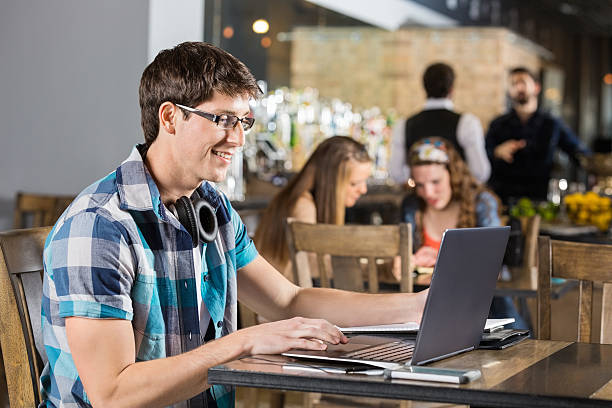 istock Young man working on laptop in coffee shop 472200273