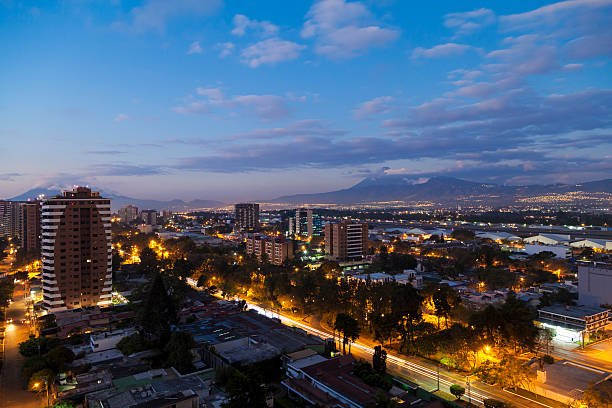 Guatemala City by dusk Zona 14, Guatemala City by night. Long exposure with light trails from cars on the Avenida Las Americas agua volcano photos stock pictures, royalty-free photos & images