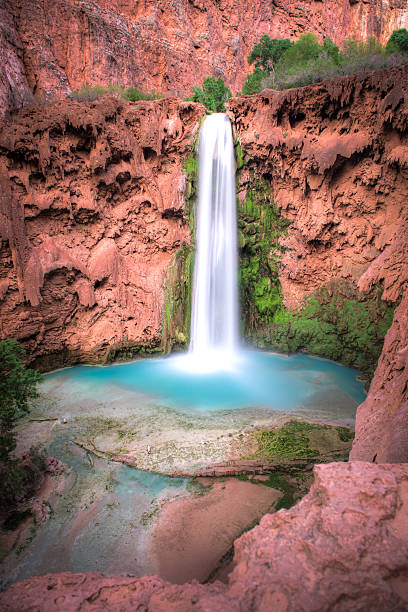 Mooney Falls Havasu Canyon The Havasupai Indian Reservation to the south of the Grand Canyon in Arizona attracts tourists year-round with its three exquisite aqua-colored waterfalls, including Mooney Falls. harasu canyon stock pictures, royalty-free photos & images