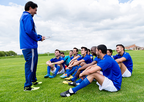 Coach talking to a group of men in a football team