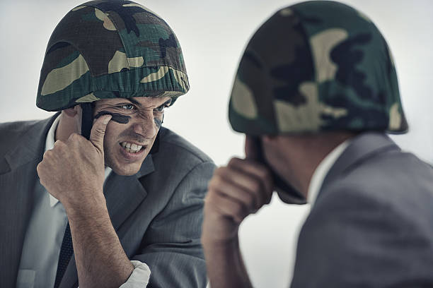 Getting ready for the upcoming battle A young man applying camouflage paint to his facehttp://195.154.178.81/DATA/i_collage/pi/shoots/783051.jpg army camouflage face paint stock pictures, royalty-free photos & images