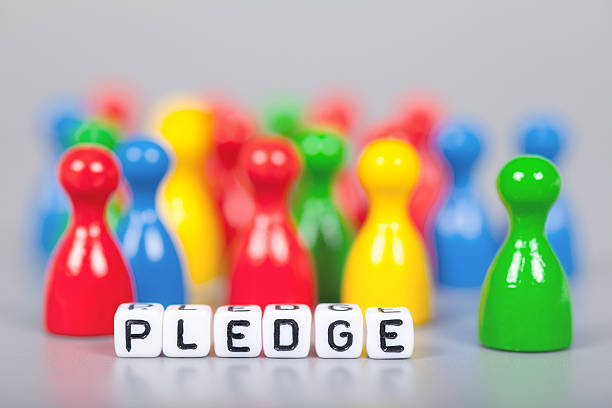 istock Cube Letters show pledge  in front of unsharp ludo figures 472204054