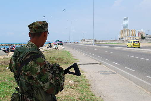 Cartagena, Colombia - May 6, 2009: A Colombian soldier stands beside a highway in the Caribbean port city of Cartagena, Colombia