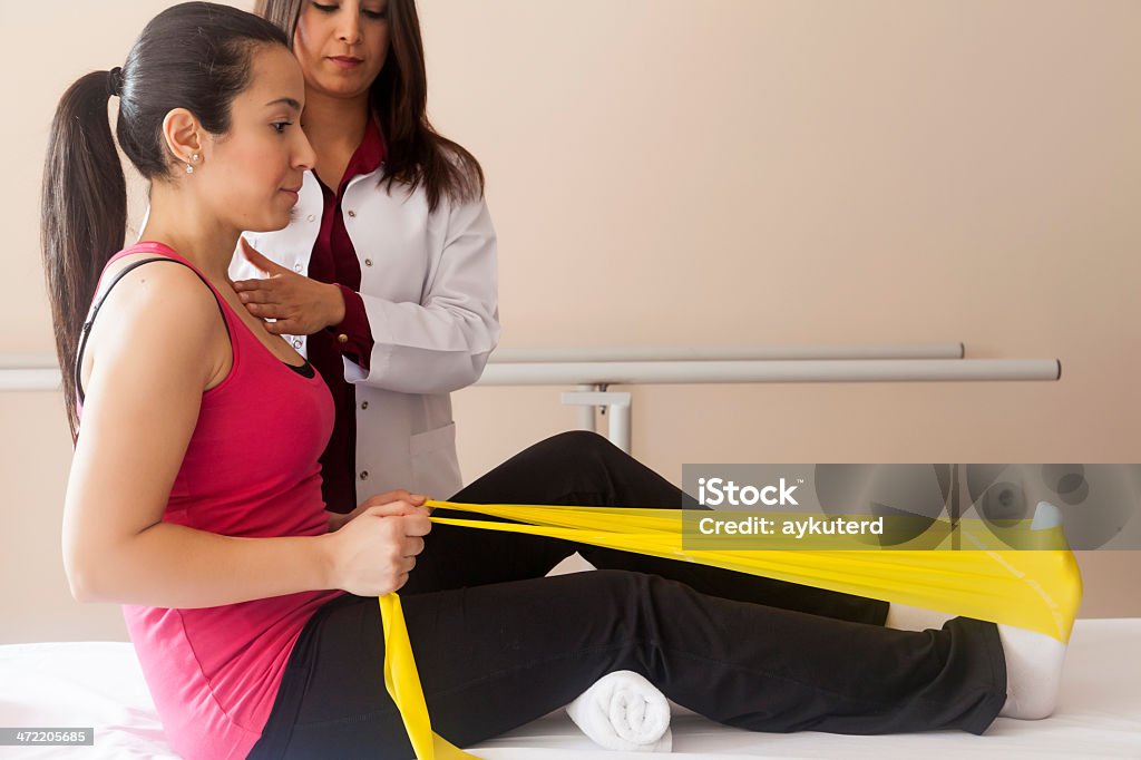 Patient doing some special exercises Patient doing some special exercises under supervision of physical therapist 25-29 Years Stock Photo