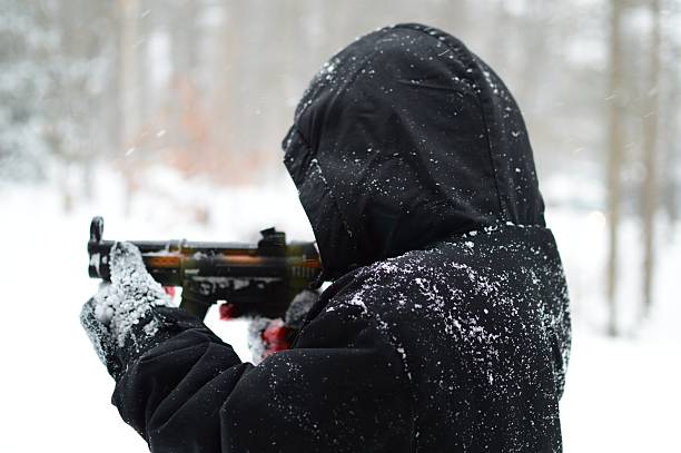 istock Small Child Plays Guns In Snowstorm 472206894
