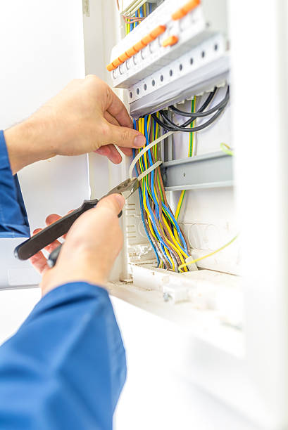 istock Electrician checking the wiring in a fuse box 472207043