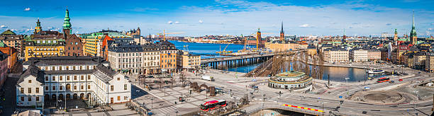 Stockholm vibrant cityscape panorama across Sodermalm and Slussen waterfront Sweden Rooftop view across the landmarks and streets of central Stockholm, from the museums and rooftops of Sodermalm, the Stadsmuseet, Sodermalmstorg and the roundabouts of Slussen, across the blue waters of Riddarfjarden to the Stadhuset on Kungsholmen, Central Station and the iconic waterfront of Gamla Stan old town. ProPhoto RGB profile for maximum color fidelity and gamut. kungsholmen town hall photos stock pictures, royalty-free photos & images