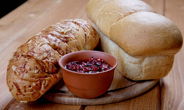 istock Long loaf of bread and jam on a table 472208081