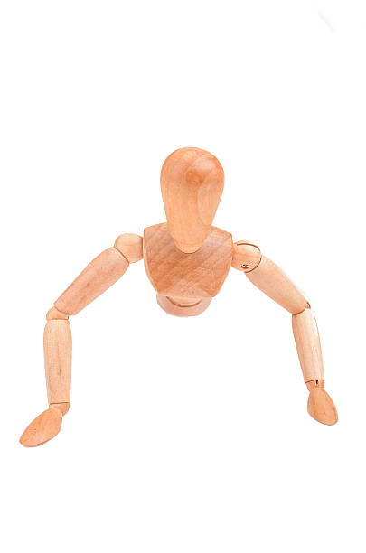 istock Jointed wooden mannequin doing push-ups isolated on white background 472209693