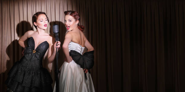 Two beautiful singers Photo in retro style . To simulate the slide in classic style were added noise and filters using Photoshop  hair band stock pictures, royalty-free photos & images
