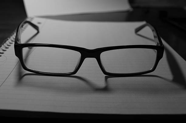istock Pair of Glasses on a Notebook Black and White 472210426