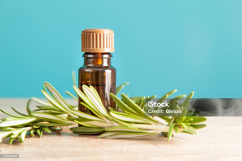 Bottle with aromatic oil and rosemary Bottle with aromatic oil and rosemary on a wooden table Bottle Stock Photo