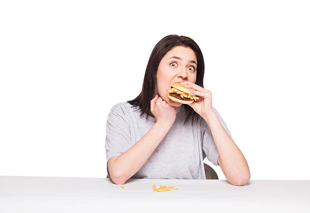 young woman eating hamburger isolated on white stock photo